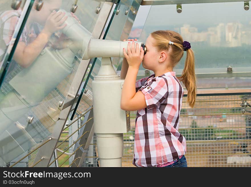 A girl looks through a telescope