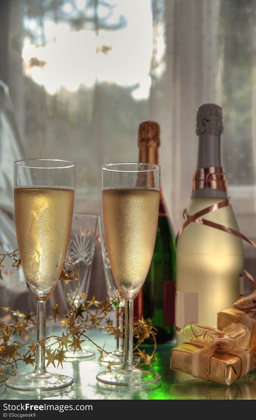 Champagne in glasses,bottles,gift boxes and sunbeam lights through the window. Champagne in glasses,bottles,gift boxes and sunbeam lights through the window.