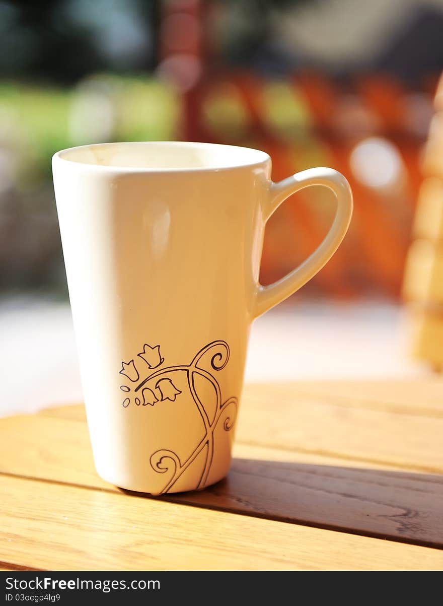 White mug on a table with outdoor setting