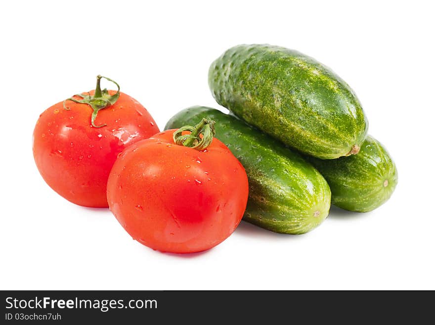 Fresh washed vegetables (cucumbers and tomatoes) over white background