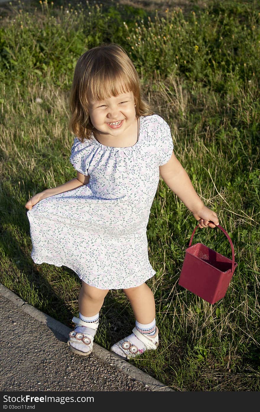 Portrait of blonde little girl outdoors in summer