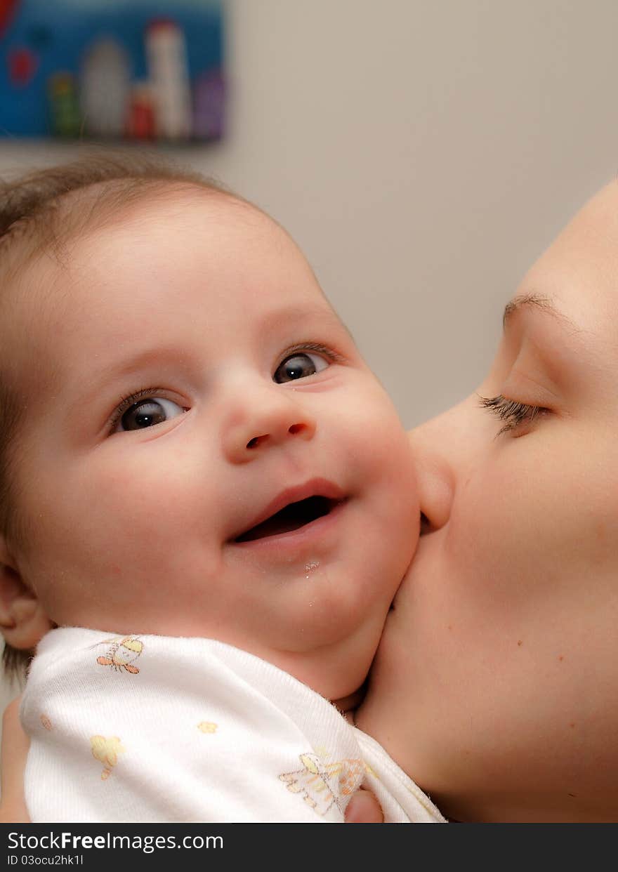 Young mother kissing a newborn son, little baby boy, beautiful and happy face, love and happiness