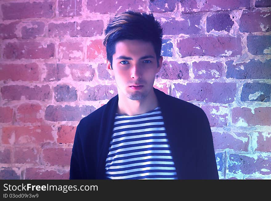 Young hadsome man in front of a brick wall. Young hadsome man in front of a brick wall