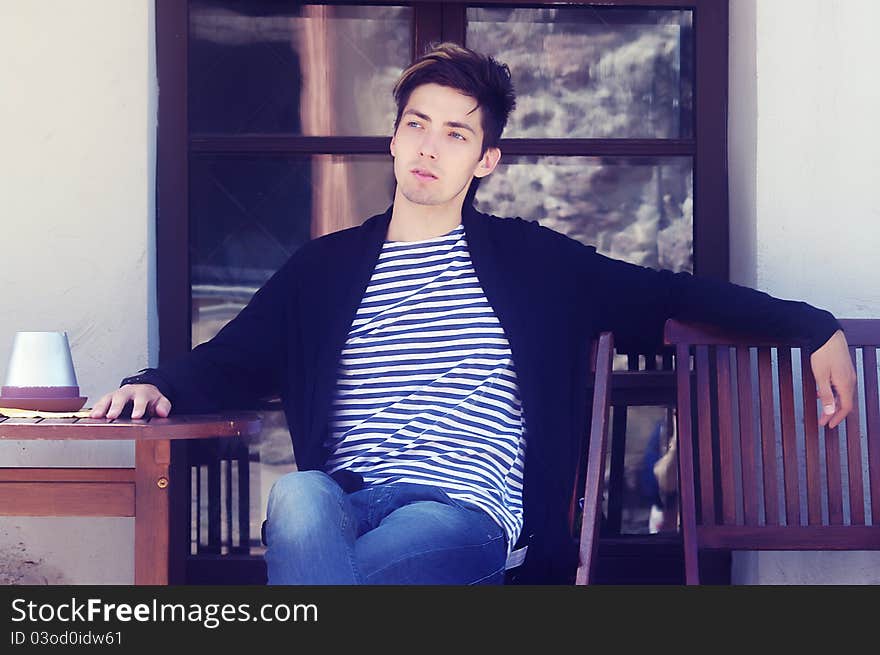 Young man sitting in cafe outside. Young man sitting in cafe outside