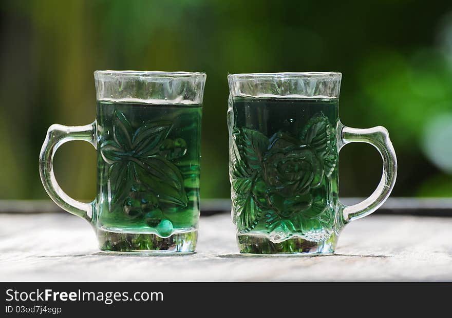 Image of glass with green water and green background