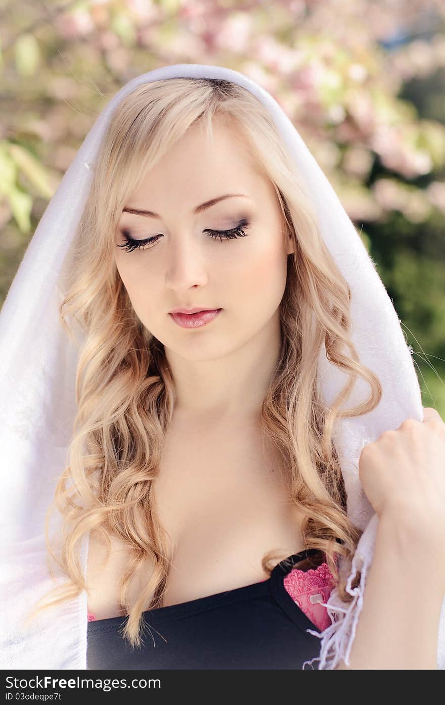 Portrait of beautiful girl with white kerchief and blooming sakura on background. Portrait of beautiful girl with white kerchief and blooming sakura on background