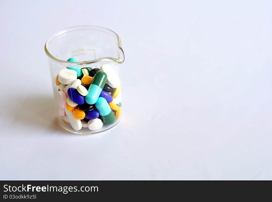 Variety of pills in a beaker