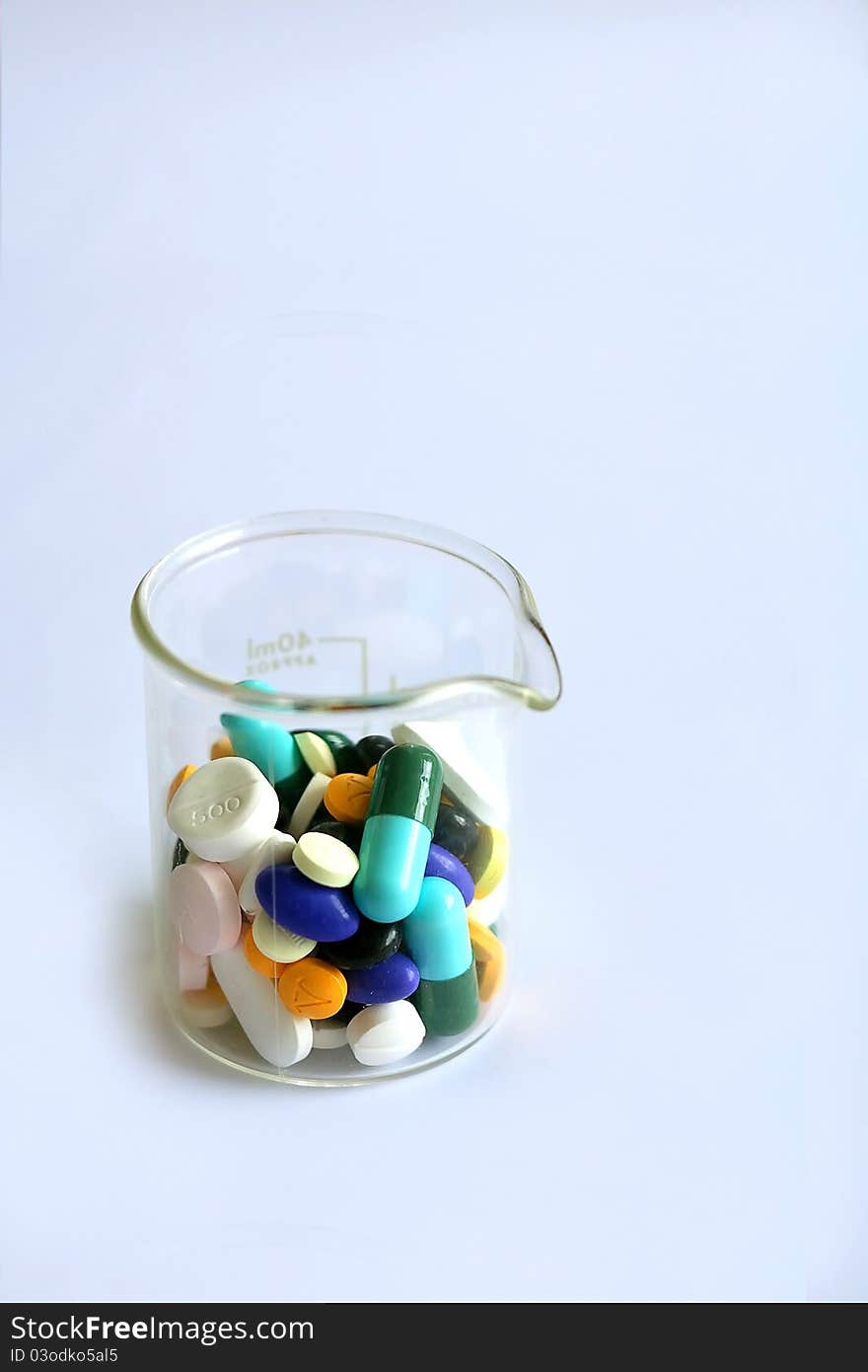 Variety of pills in a beaker