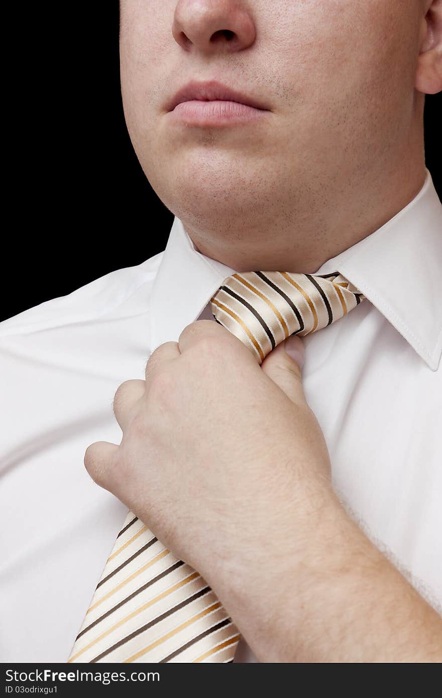 The man a hand corrects a light striped tie (face in focus). The man a hand corrects a light striped tie (face in focus)