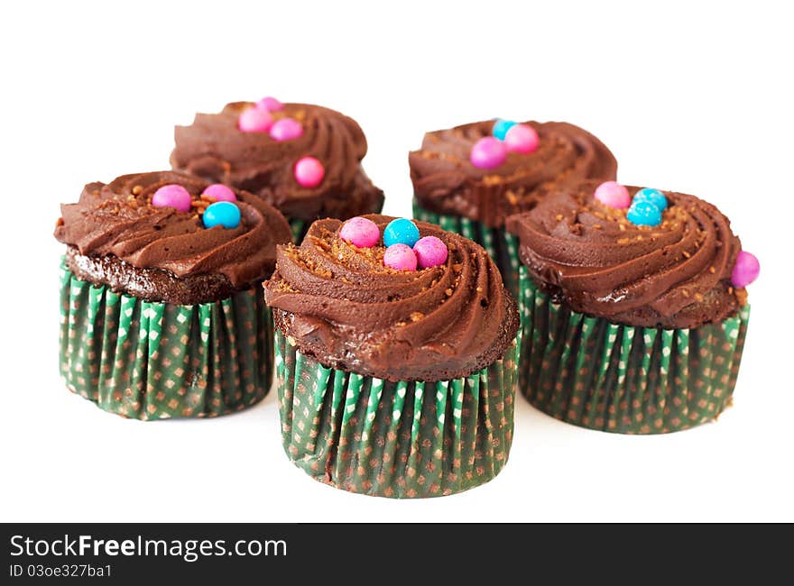 Miniature decorated chocolate cupcakes on white background. Miniature decorated chocolate cupcakes on white background