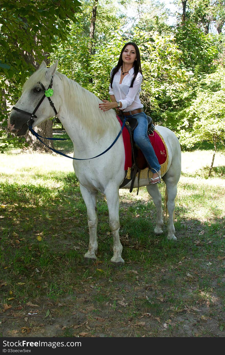 Woman with black hair on a white horse