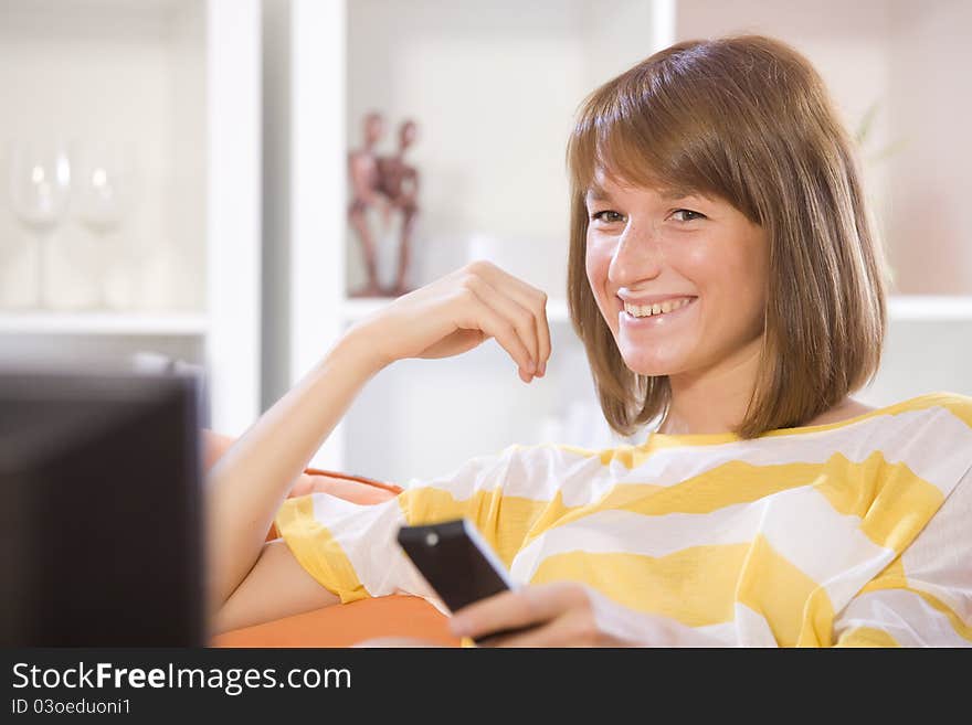 Woman smiling while watching television at home