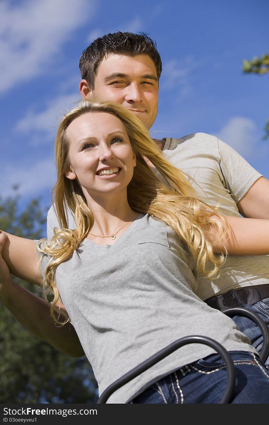 Happy young couple on a swing outdoor