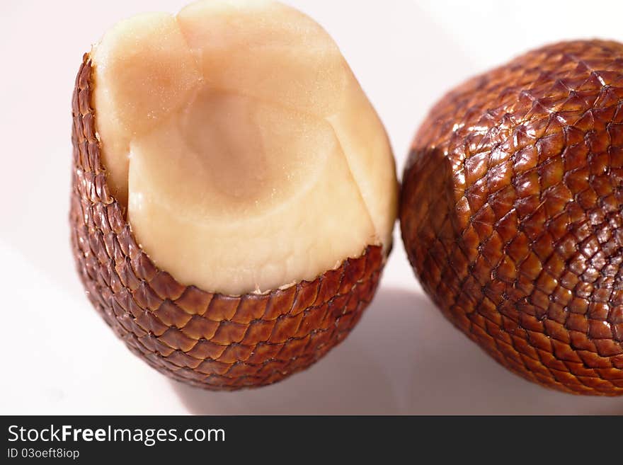 These are salak fruits. the skin is scaly-reddish brown. very well netting skin structures. by pinching the tip, it can be pulled away. the fruit inside consists of three fleshy lobes, each contains a large inedible seed. the taste is usually crunchy and sweet-sour.