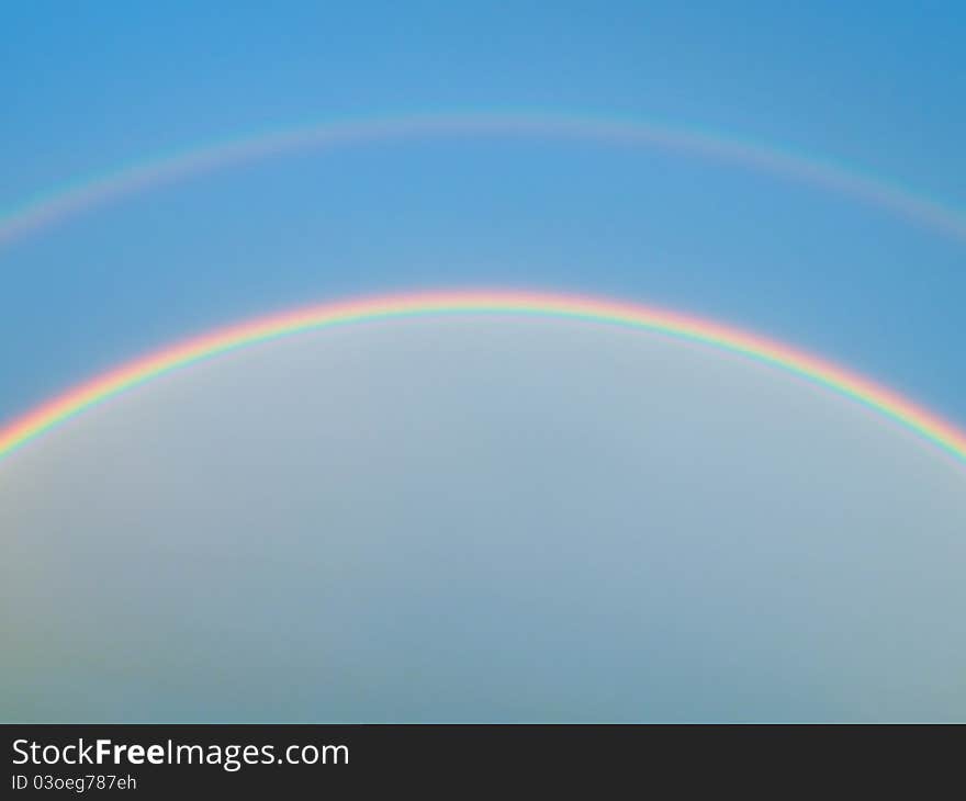 Detail of a rainbow on the blue sky in summer time. Detail of a rainbow on the blue sky in summer time