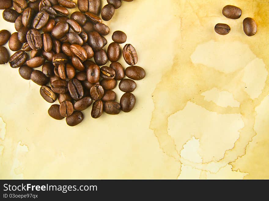 Freshly Roasted Coffee Beans on a Texture of Stained Paper