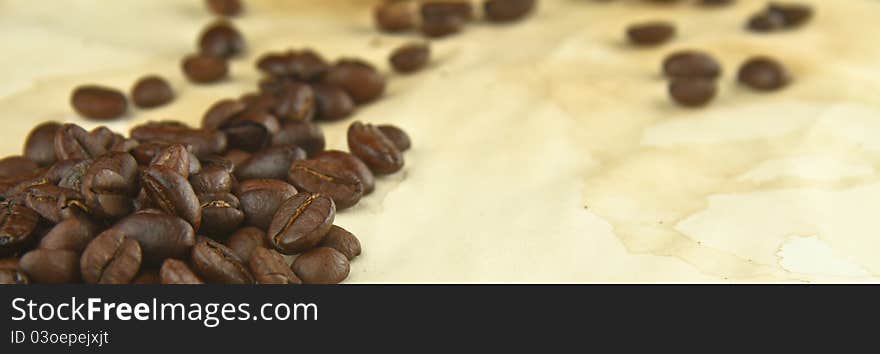 Freshly Roasted Coffee Beans on a Texture of Stained Paper