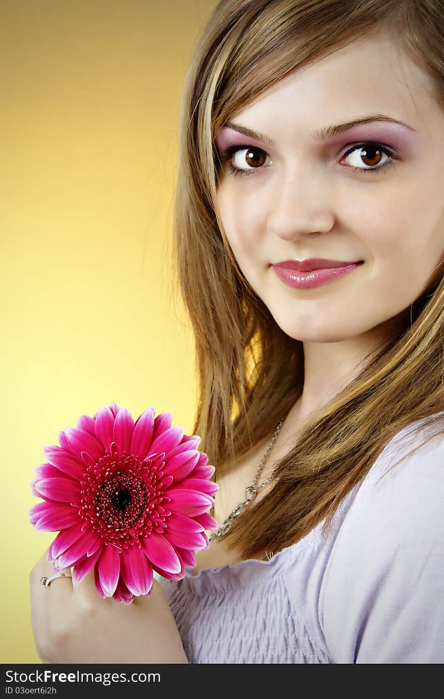 Attractive smiling woman portrait on yellow background