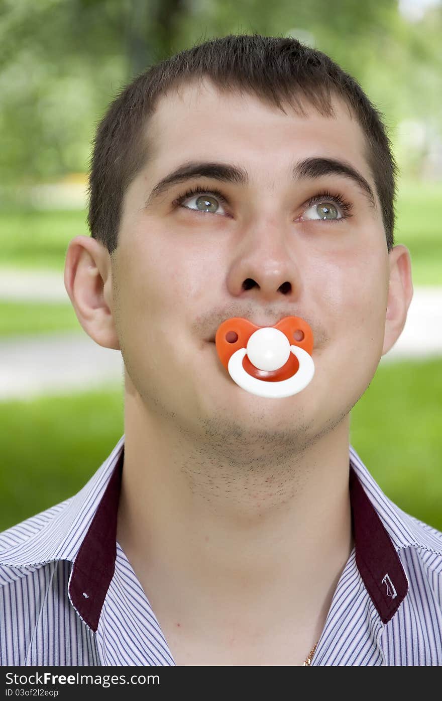 The man holds a dummy in a mouth. The man holds a dummy in a mouth