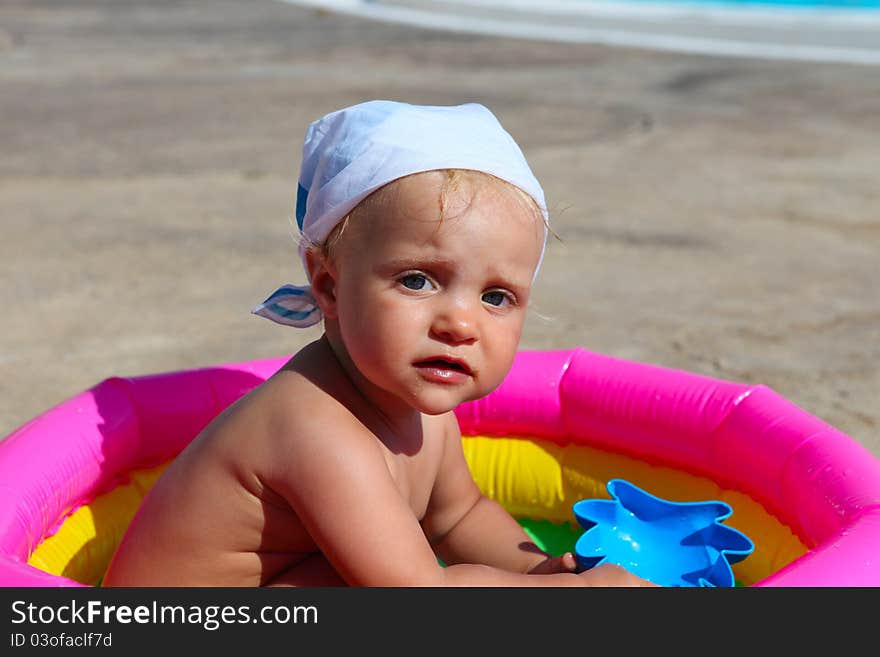 Baby girl playing in a colorful pool