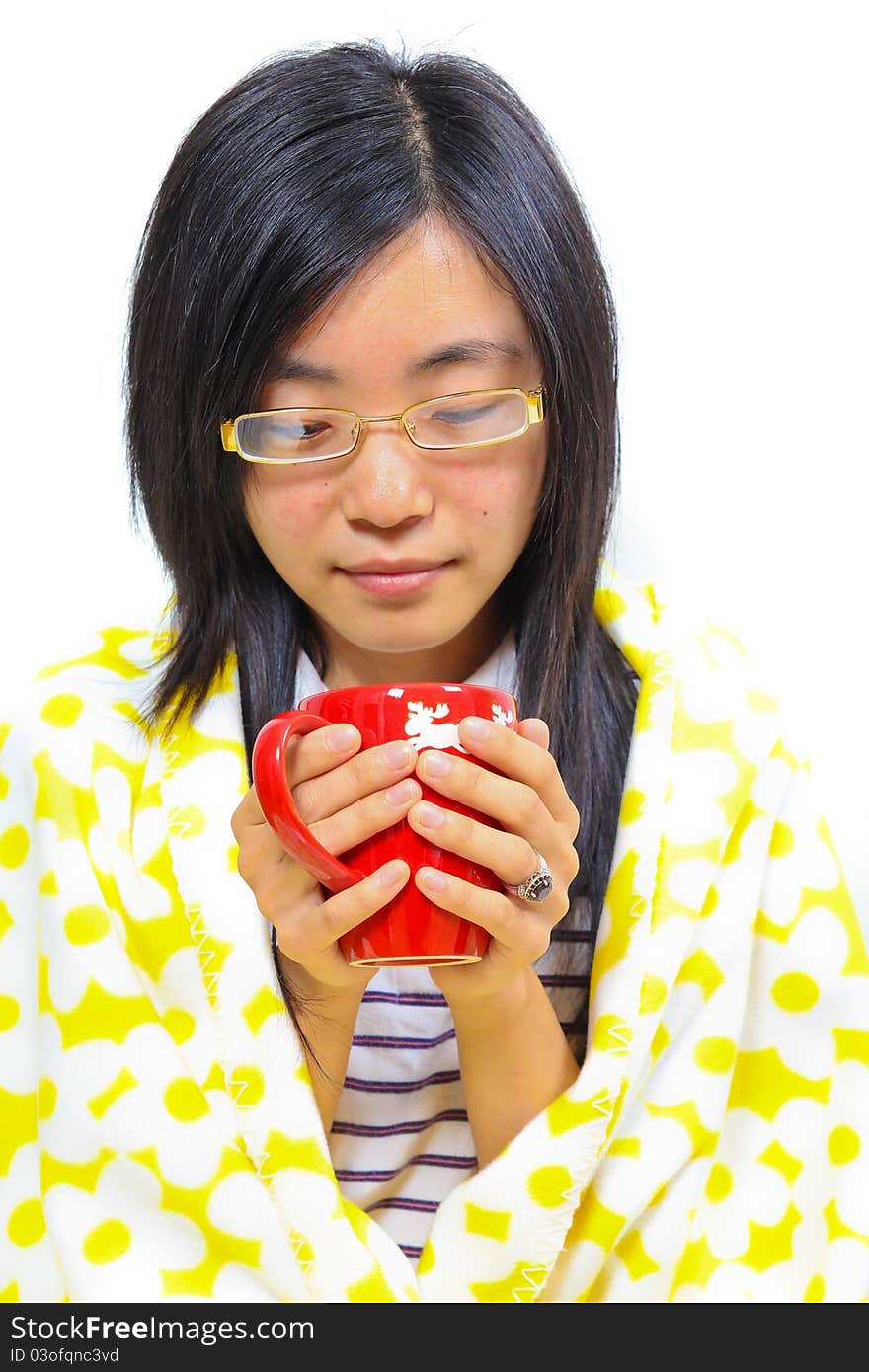 Chinese woman sitting under a blanket with a cup of tea