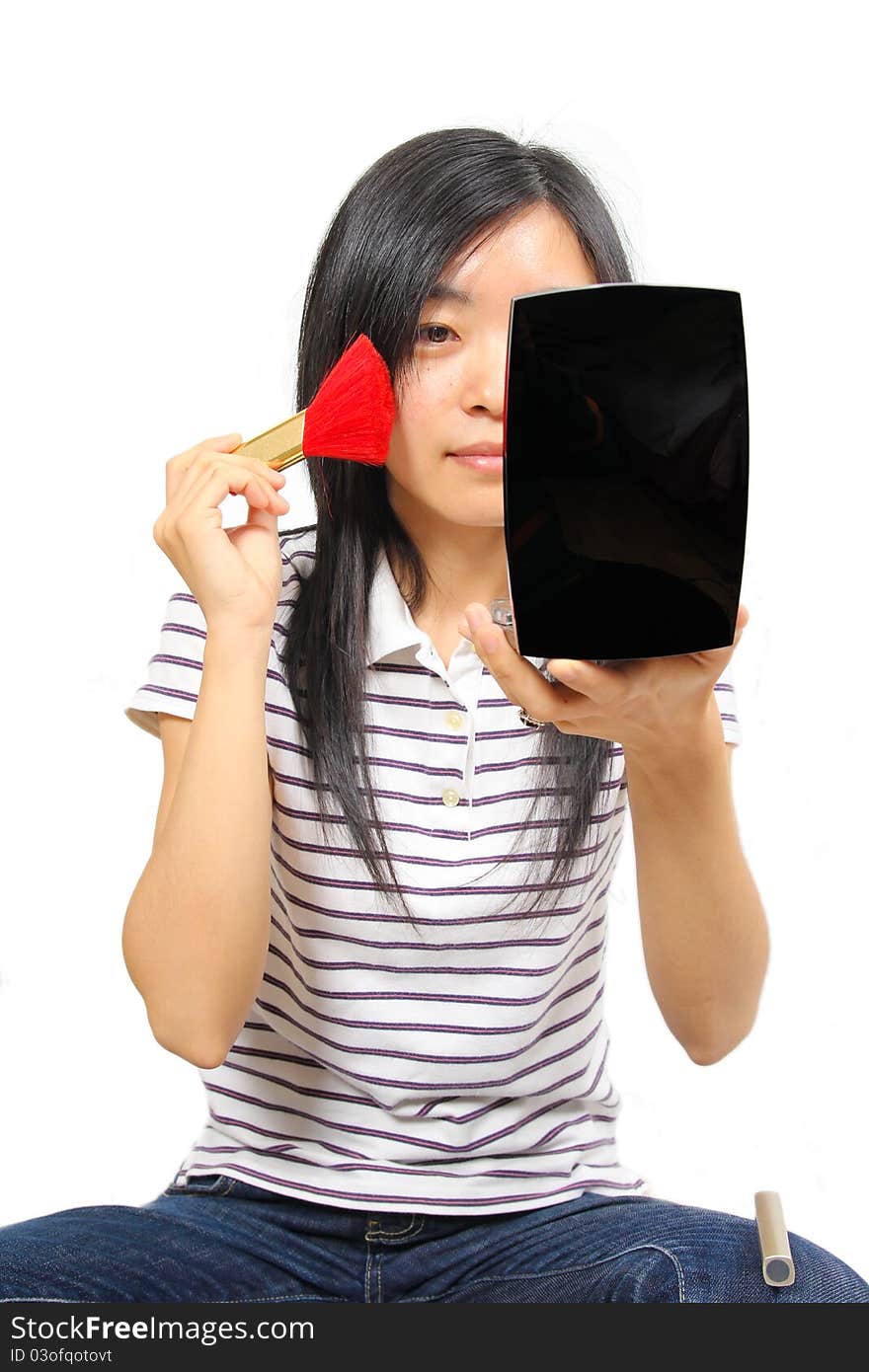 Young chinese woman putting on makeup. White background