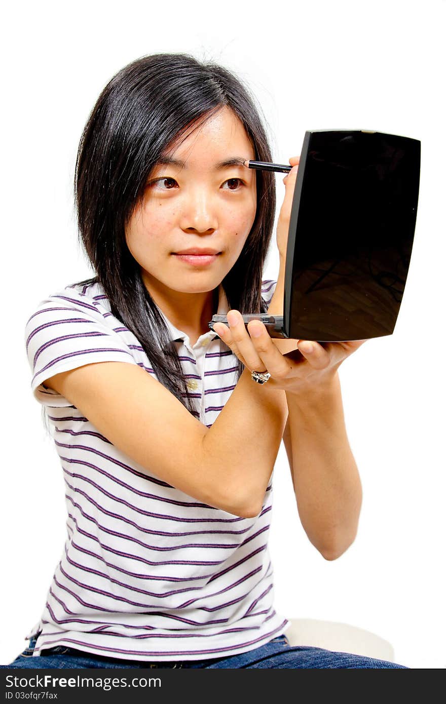 Young chinese woman putting on makeup. White background