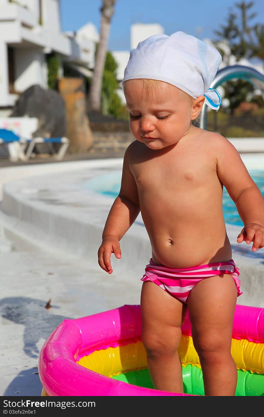 Baby girl playing in a colorful pool