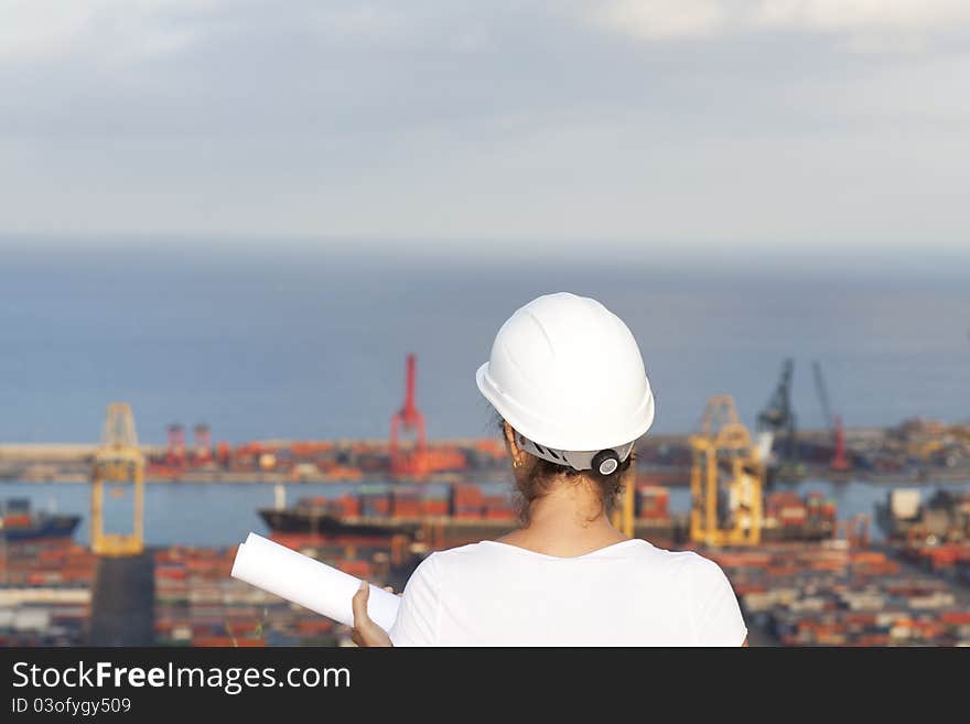 Engineer with a drawing in hand looks at port. Engineer with a drawing in hand looks at port