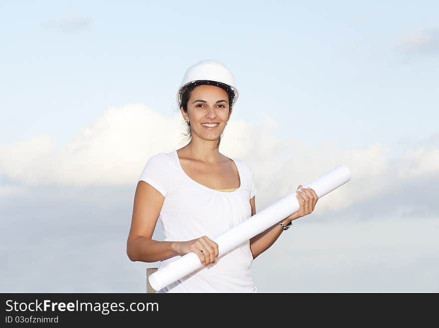 Engineer with a drawing in hand against blue sky