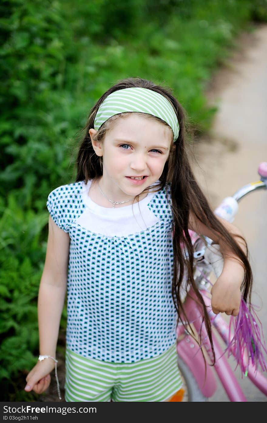 Long-haired Child Girl Poses With Pink Bycicle