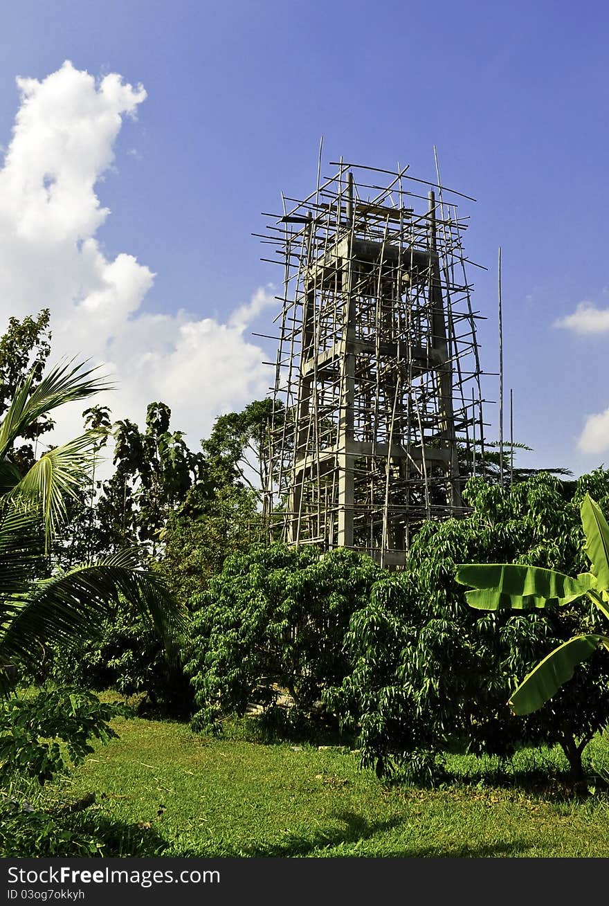 A large tower being constructed in a rural area of Asia. A large tower being constructed in a rural area of Asia