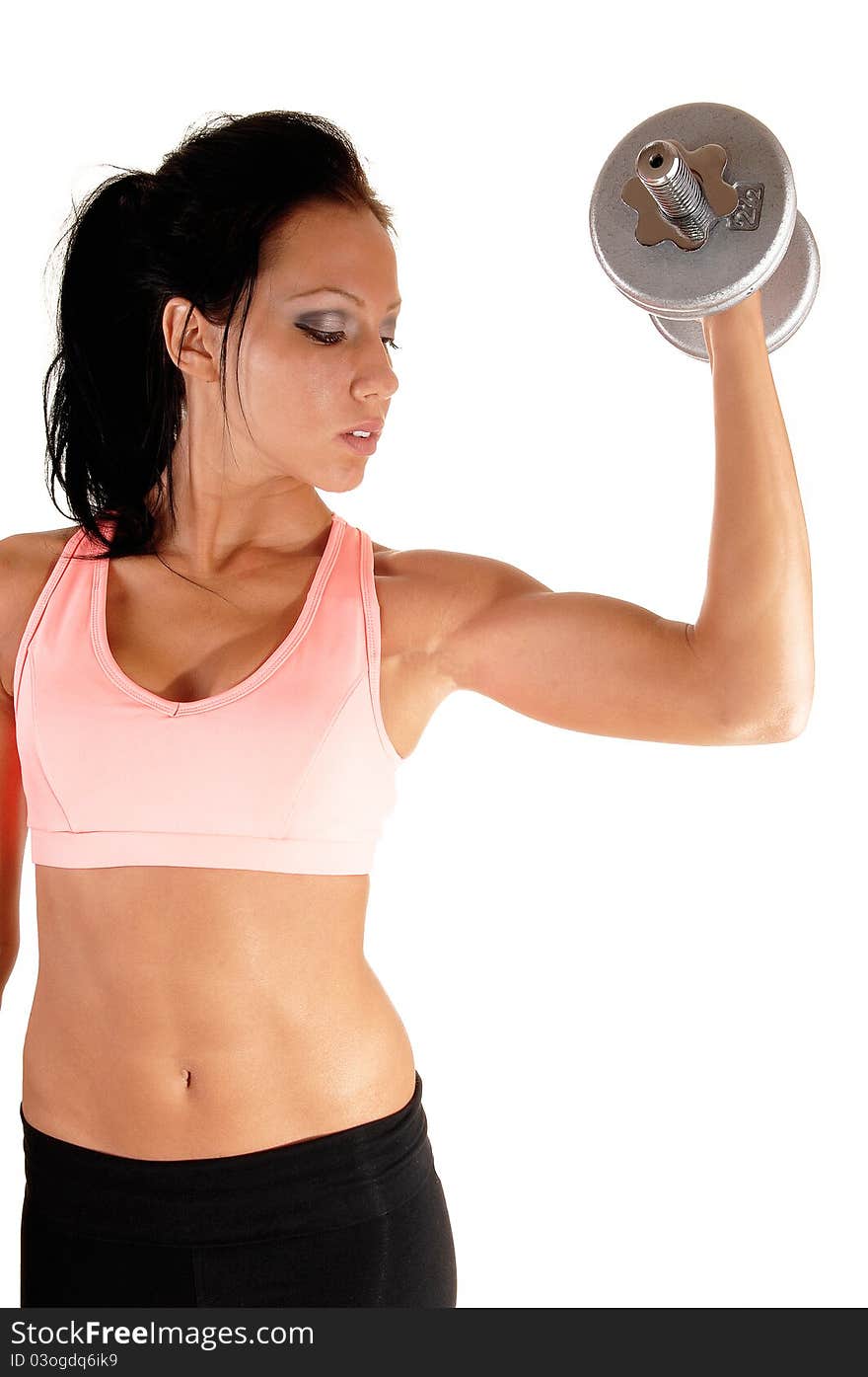 Pretty young woman lifting a dumbbell with her left arm showing her muscles and very lean body, for white background. Pretty young woman lifting a dumbbell with her left arm showing her muscles and very lean body, for white background.