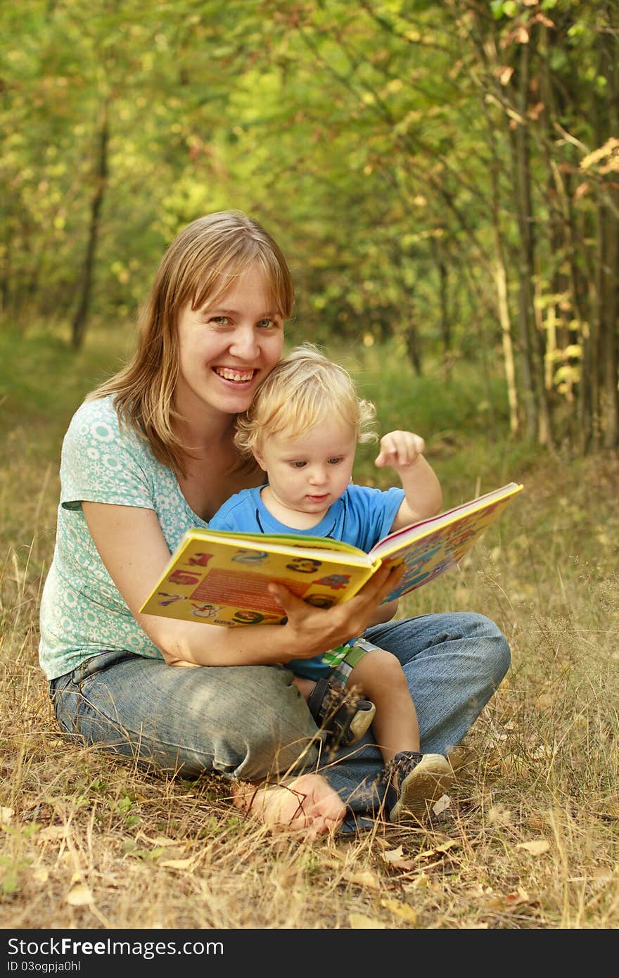 Mother and son reading book in summer nature. Mother and son reading book in summer nature