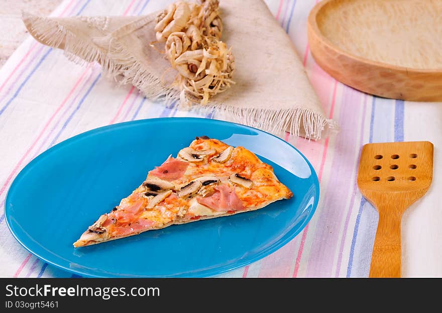 Italian delicious baked pizza on a blue plate. Italian delicious baked pizza on a blue plate