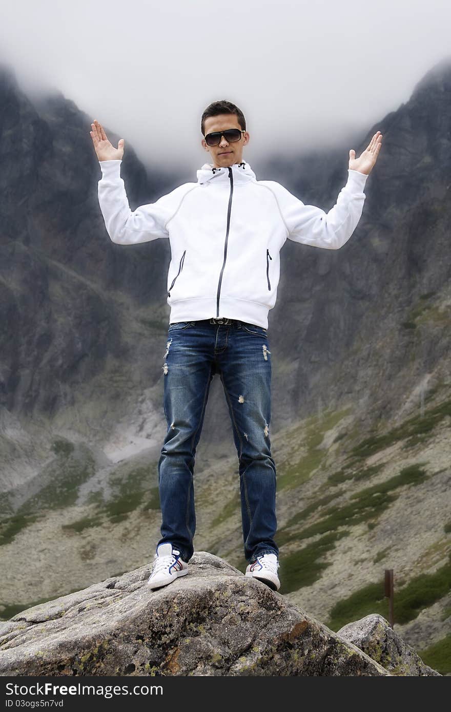 Young man posing on the top of a rock