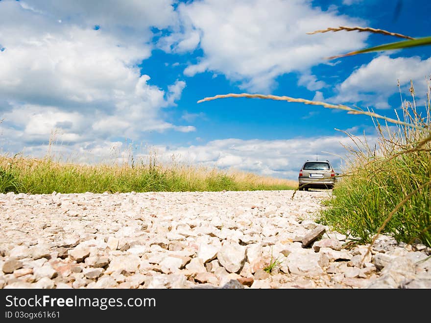 Country road, stone road under fluffy clouds, fall scenic road