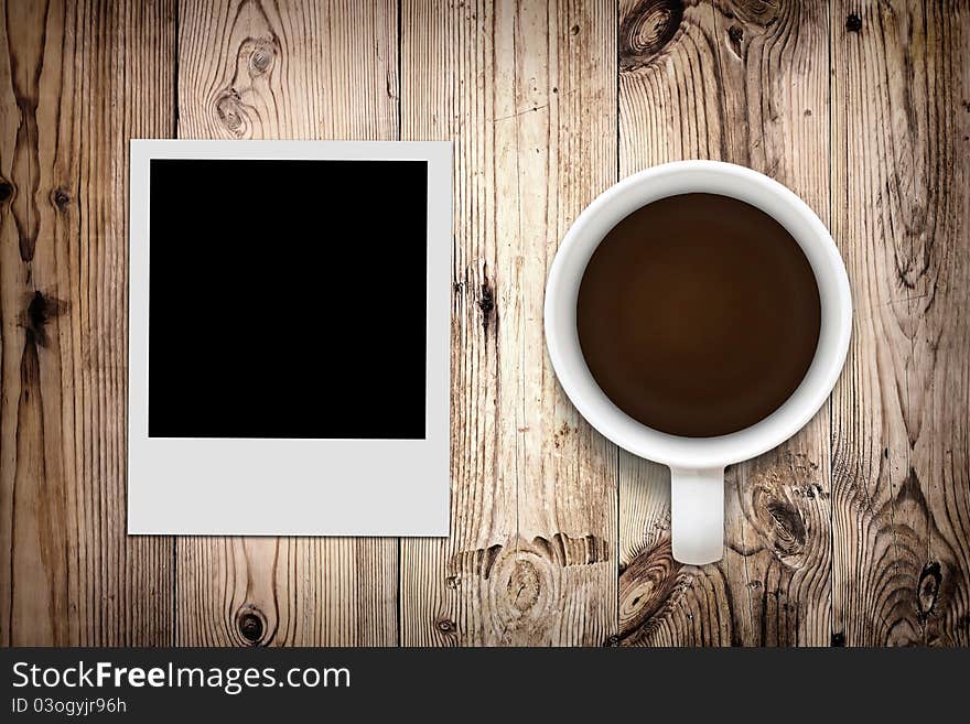 Blank photo and coffee on wooden background