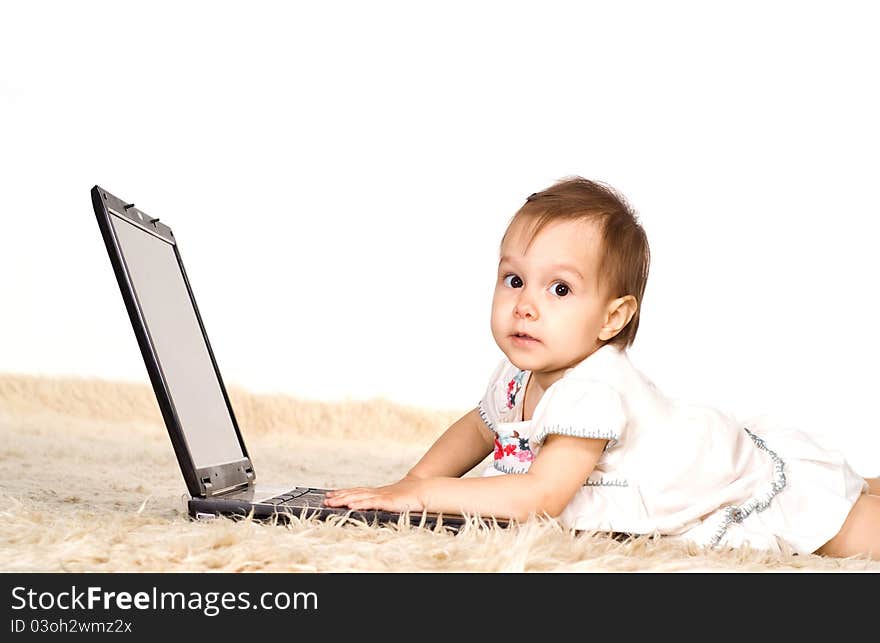 Cute little girl with laptop on a carpet. Cute little girl with laptop on a carpet