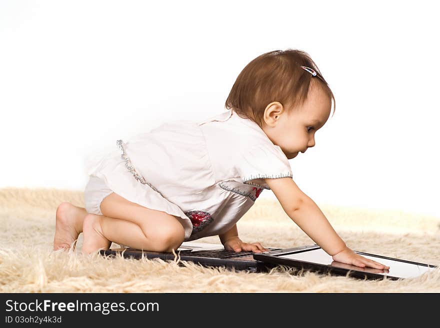 Cute little girl with laptop on a carpet. Cute little girl with laptop on a carpet