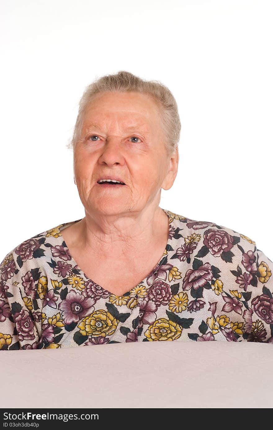 Cute granny posing at table on a white. Cute granny posing at table on a white