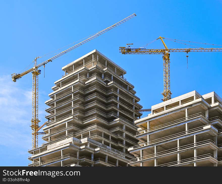 Two elevating cranes on a skyscraper building site. Two elevating cranes on a skyscraper building site