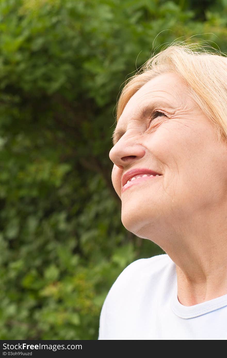 Portrait of cute old woman at nature