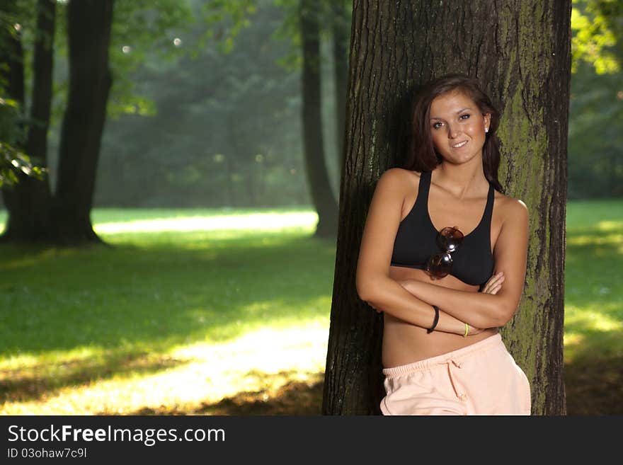 Attractive young woman standing by the tree