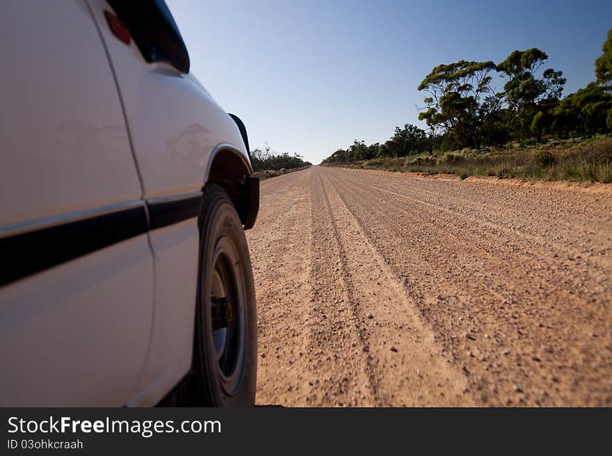 Four wheel drive vehicle traveling down unsealed country road. Four wheel drive vehicle traveling down unsealed country road