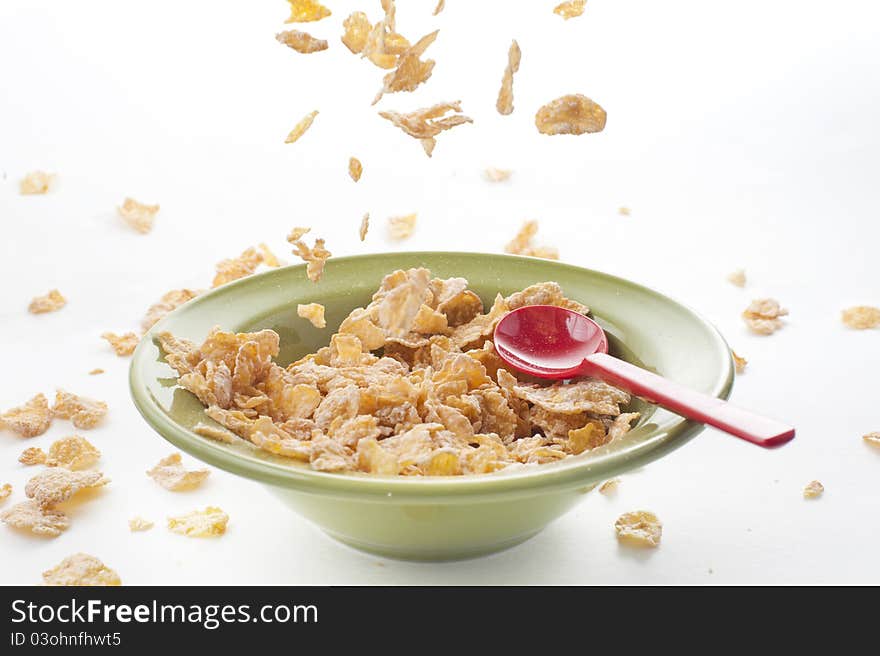 Cereal falling on the bowl with red spoon, healthy breakfast food