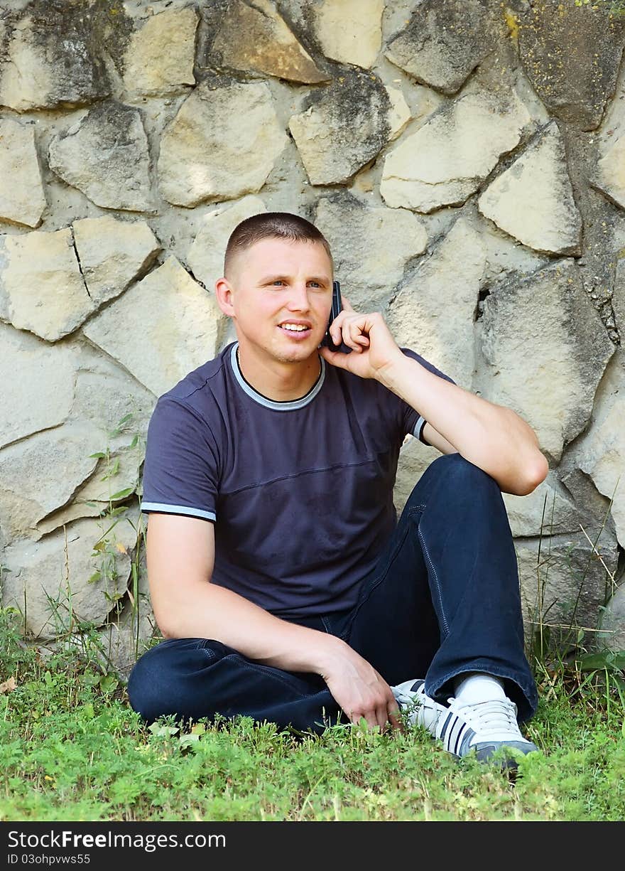 The young man with phone on picnic(park)