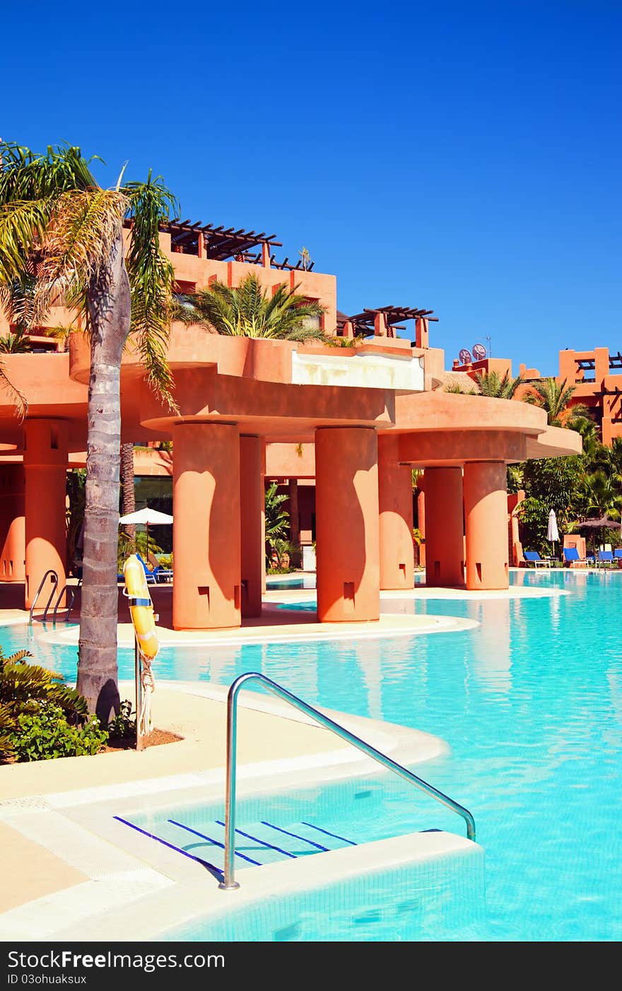 Swimming pool with palm trees and blue sky in luxury hotel. Swimming pool with palm trees and blue sky in luxury hotel