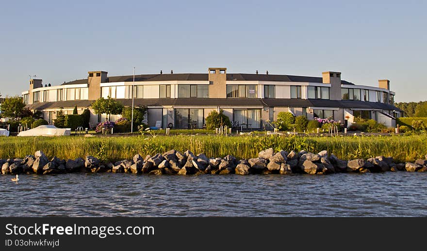 A flat building beside a river. A flat building beside a river