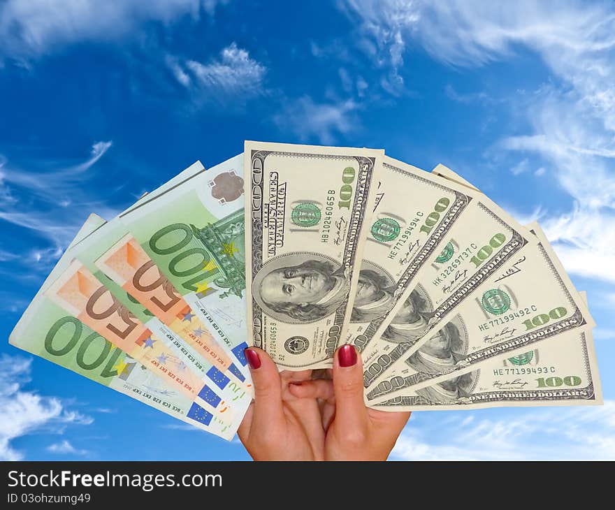 Women's hands are holding the dollar and euro banknotes